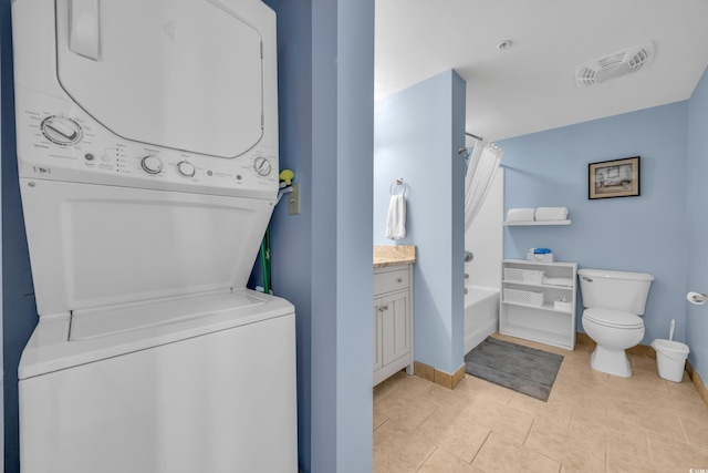 washroom featuring stacked washer and dryer and light tile patterned flooring