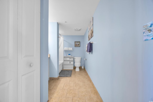 bathroom with toilet, tile patterned flooring, and a bathing tub