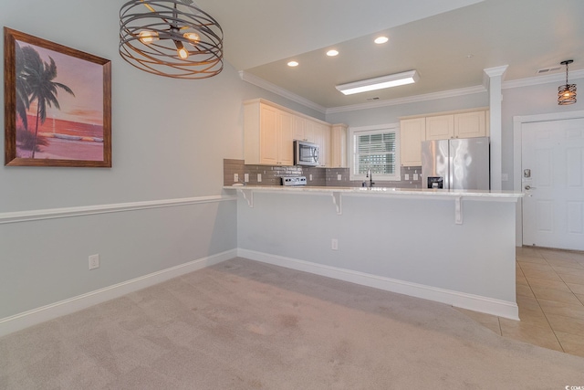 kitchen with a kitchen bar, ornamental molding, kitchen peninsula, pendant lighting, and stainless steel appliances