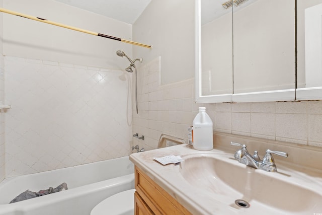 full bathroom featuring toilet, tiled shower / bath combo, and vanity