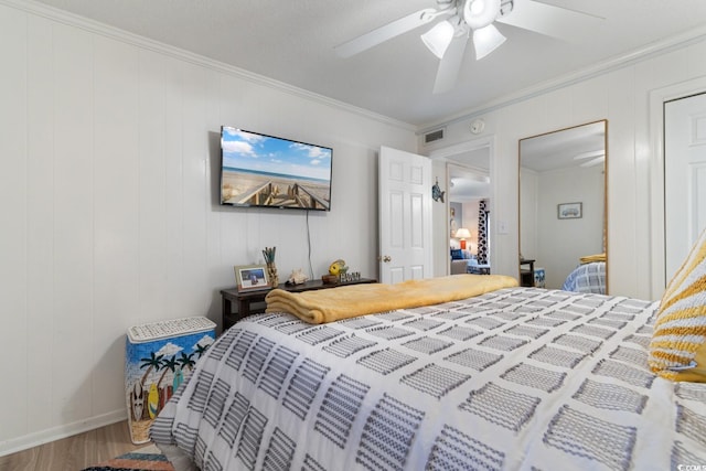 bedroom with ceiling fan, crown molding, and hardwood / wood-style floors