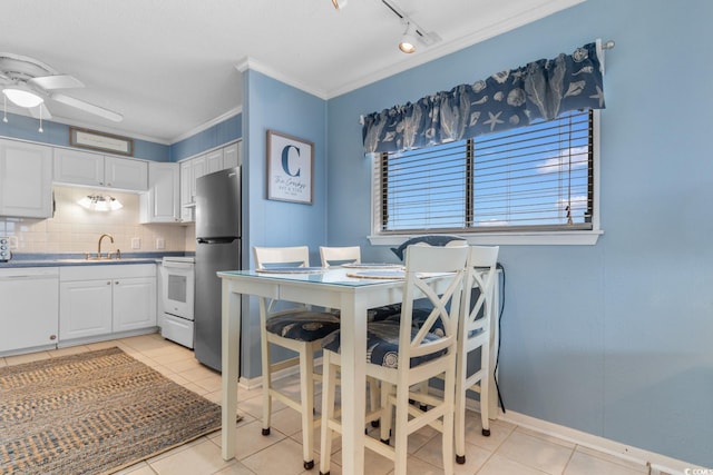 dining space featuring track lighting, sink, ceiling fan, light tile patterned floors, and crown molding