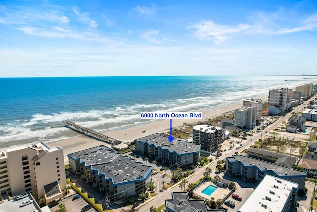 birds eye view of property featuring a beach view and a water view