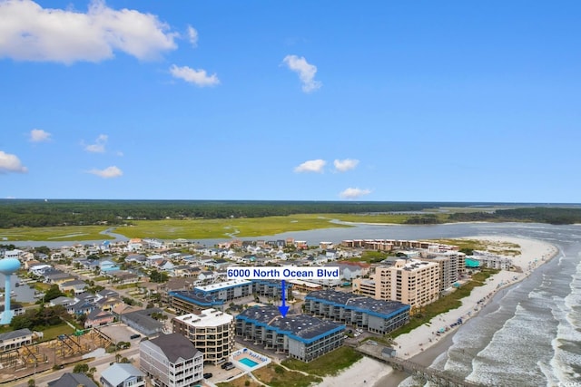 birds eye view of property with a water view and a view of the beach