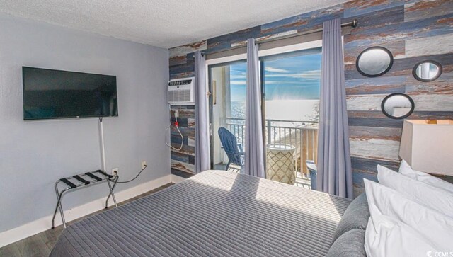 unfurnished bedroom with access to exterior, a textured ceiling, and wood-type flooring