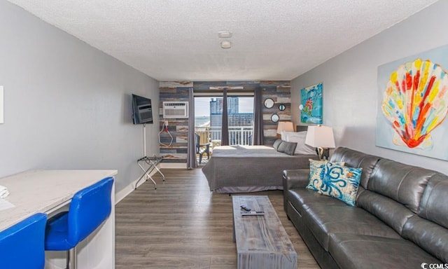 bedroom featuring a textured ceiling, dark wood-type flooring, and a wall mounted AC