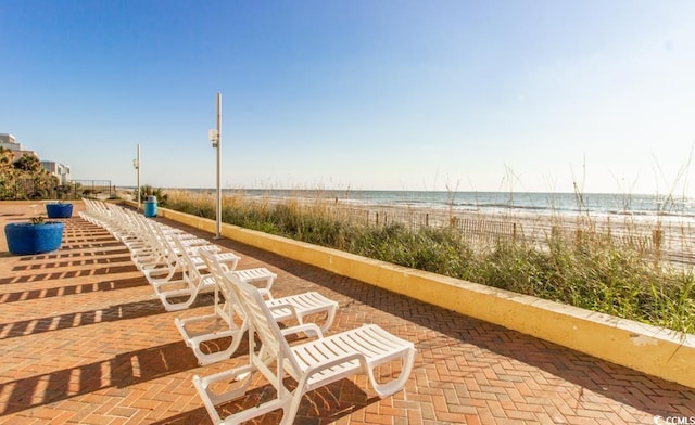 view of home's community with a water view and a beach view