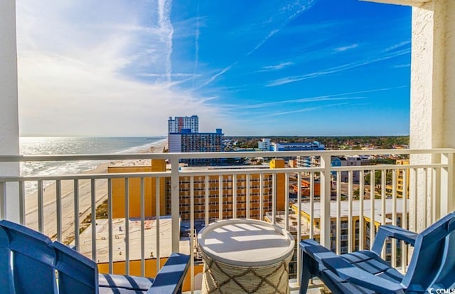 balcony featuring a grill, a water view, and a view of the beach