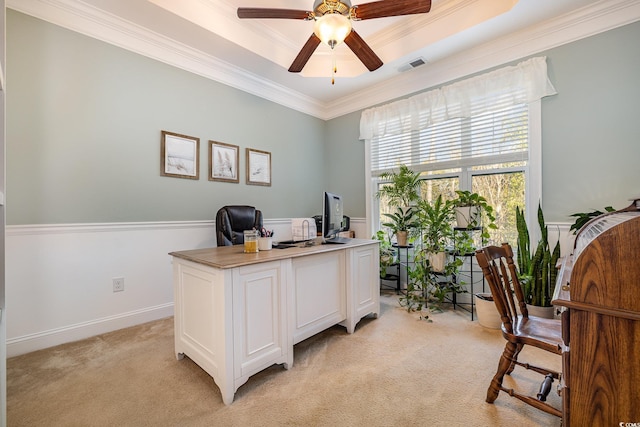 carpeted office featuring ceiling fan, ornamental molding, and a raised ceiling