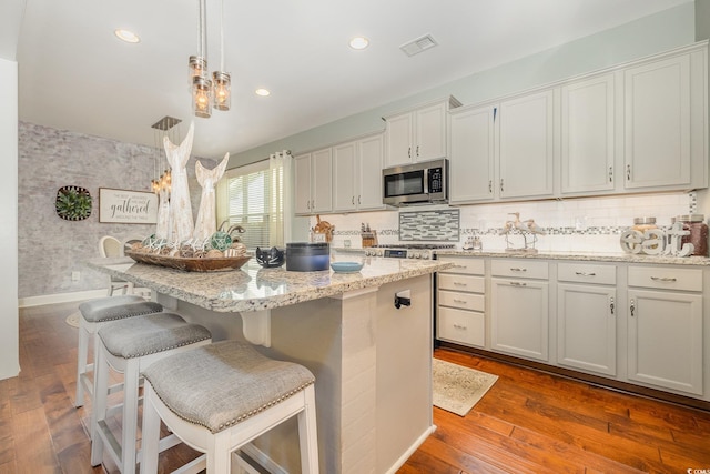 kitchen with hardwood / wood-style floors, white cabinetry, and a kitchen island