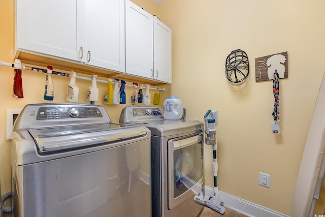 clothes washing area with tile patterned flooring, independent washer and dryer, and cabinets