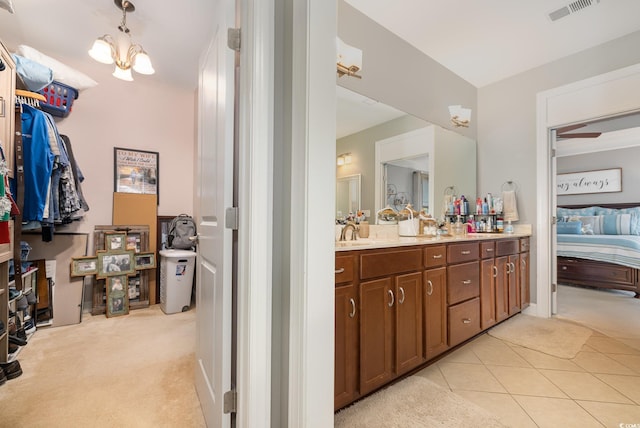 bathroom featuring an inviting chandelier, tile patterned floors, and vanity