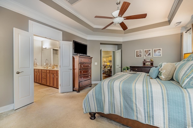 carpeted bedroom featuring ceiling fan, ensuite bathroom, crown molding, and a tray ceiling