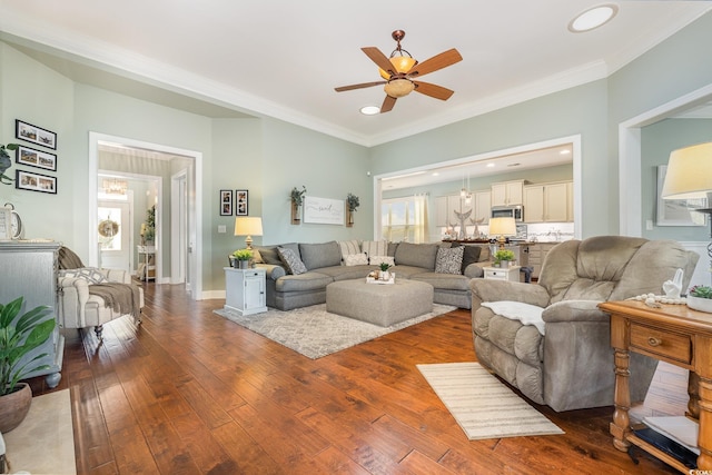 living room featuring ceiling fan, dark wood-type flooring, and crown molding