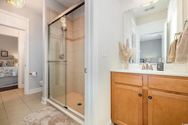 bathroom with toilet, tile patterned flooring, walk in shower, and vanity