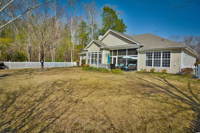 back of property with a lawn and a sunroom