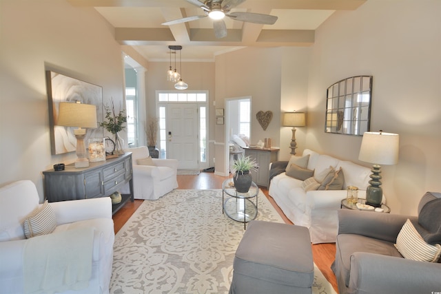 living room featuring beamed ceiling, wood-type flooring, coffered ceiling, and ornate columns