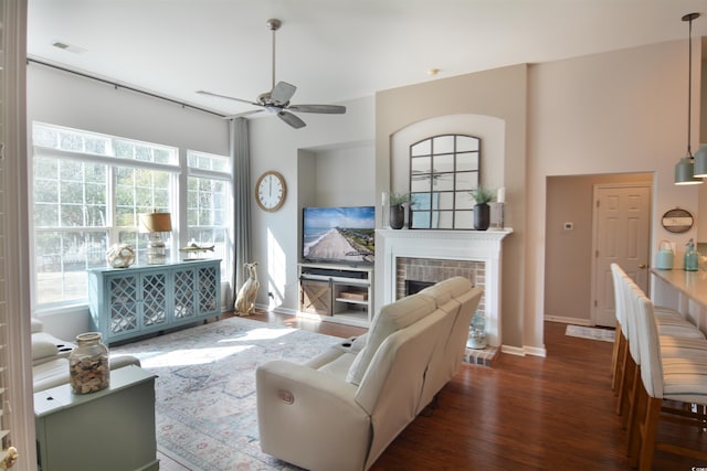 living room with ceiling fan, dark hardwood / wood-style floors, and a fireplace