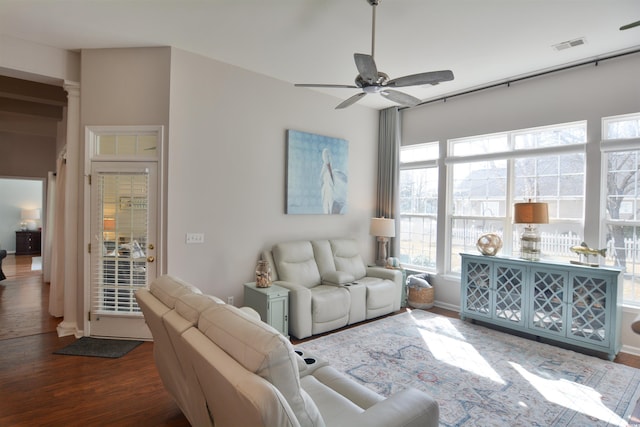 living room with ceiling fan, dark hardwood / wood-style floors, and ornate columns