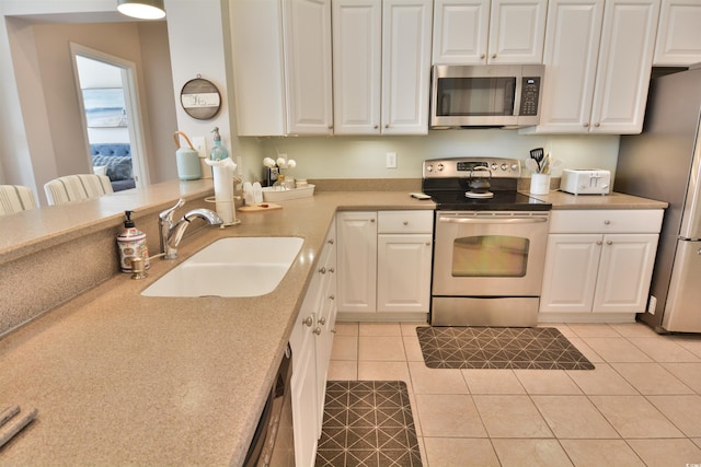 kitchen featuring stainless steel appliances, sink, and white cabinets