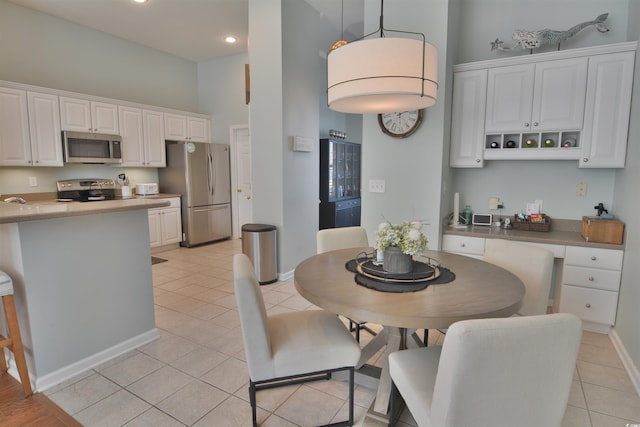 dining space with light tile patterned floors and a towering ceiling