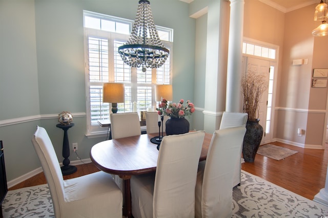 dining room with decorative columns, plenty of natural light, hardwood / wood-style floors, and a chandelier