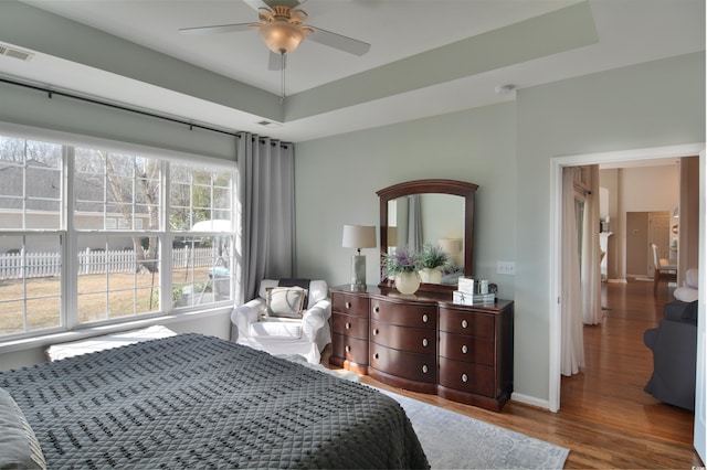 bedroom featuring hardwood / wood-style flooring and a raised ceiling