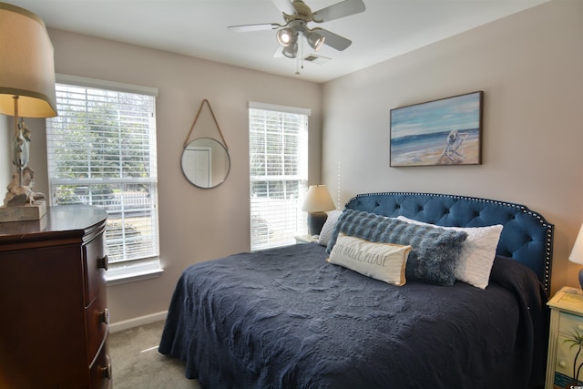 carpeted bedroom featuring ceiling fan and multiple windows