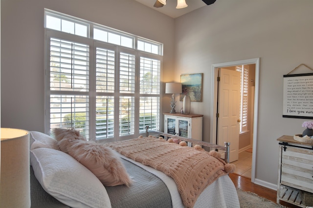 bedroom with ensuite bathroom, ceiling fan, and light hardwood / wood-style flooring