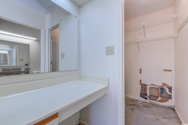 bathroom featuring a textured ceiling and concrete flooring