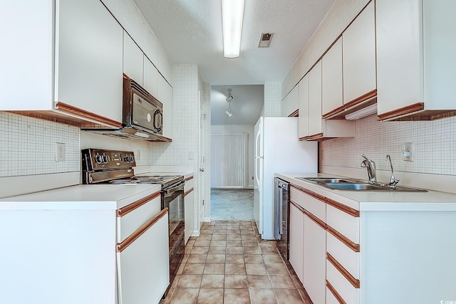 kitchen with sink, black appliances, white cabinetry, and a textured ceiling