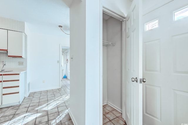 hall with sink and light tile patterned floors