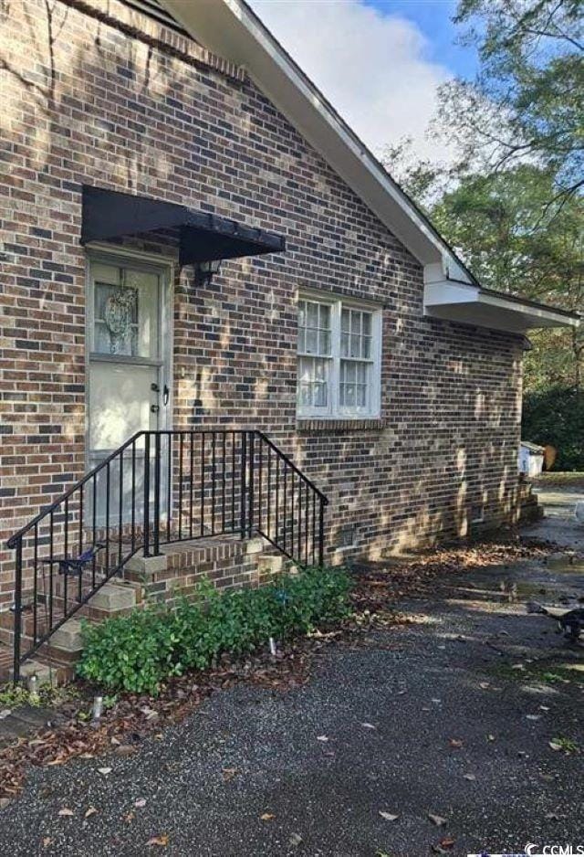 view of exterior entry with brick siding