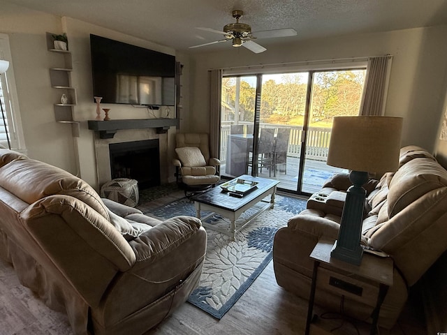 living room featuring ceiling fan and a textured ceiling