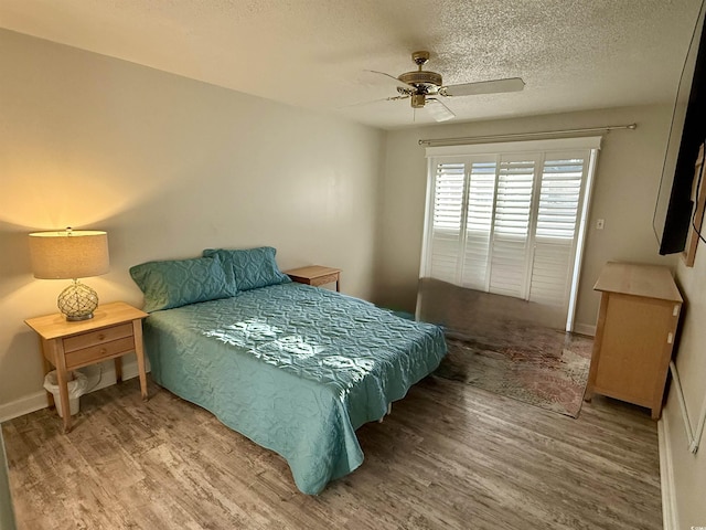 bedroom featuring hardwood / wood-style flooring, ceiling fan, and a textured ceiling