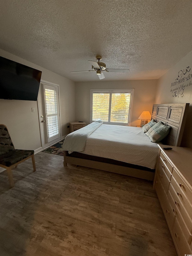 bedroom featuring hardwood / wood-style floors, a textured ceiling, ceiling fan, and access to exterior