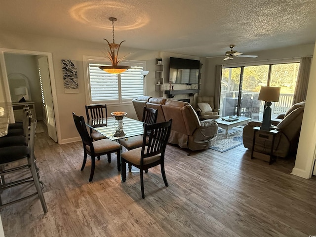 dining space with ceiling fan, hardwood / wood-style floors, and a textured ceiling