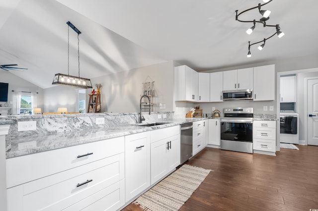 kitchen featuring washer / dryer, white cabinetry, appliances with stainless steel finishes, decorative light fixtures, and lofted ceiling