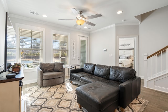 living room featuring hardwood / wood-style flooring, ornamental molding, and ceiling fan