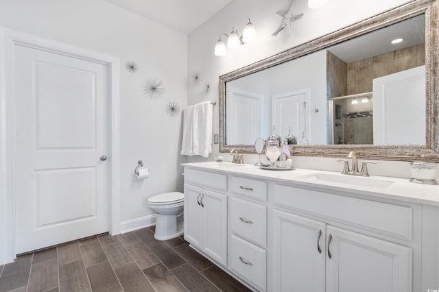 bathroom with walk in shower, vanity, and toilet