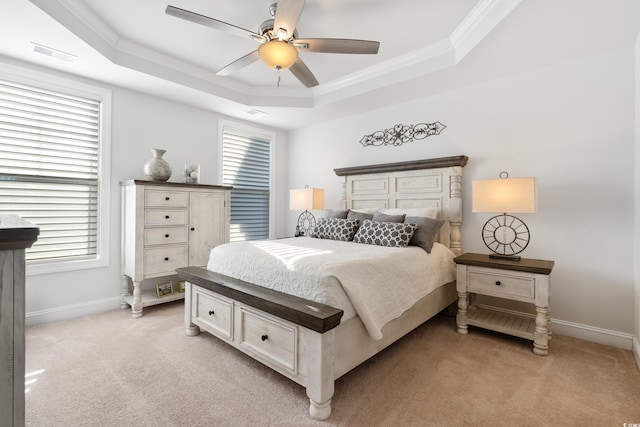 bedroom featuring ornamental molding, light colored carpet, a raised ceiling, and ceiling fan