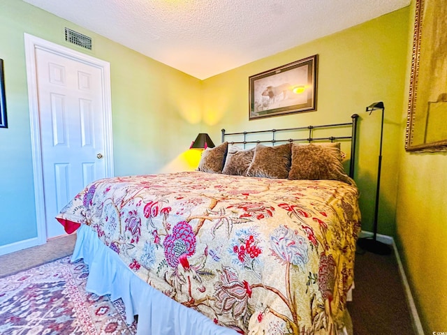 bedroom with a textured ceiling and carpet floors