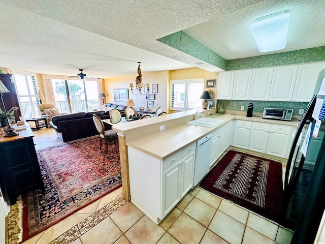 kitchen featuring white cabinetry, dishwasher, kitchen peninsula, and sink