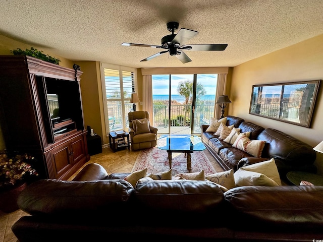 living room featuring ceiling fan, a healthy amount of sunlight, and a textured ceiling