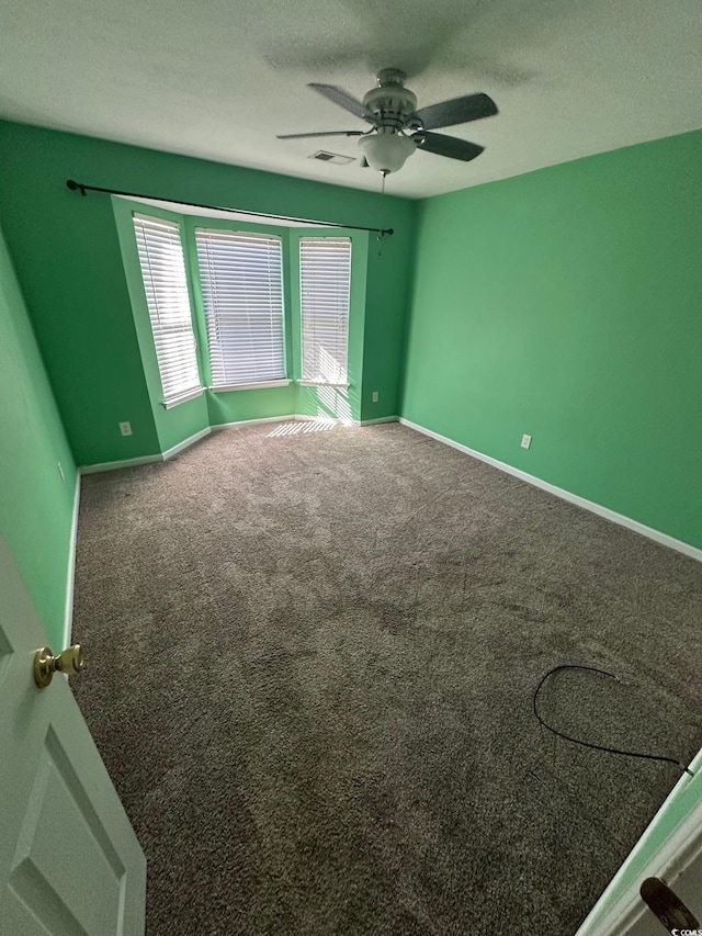 unfurnished room with carpet flooring, a textured ceiling, and ceiling fan