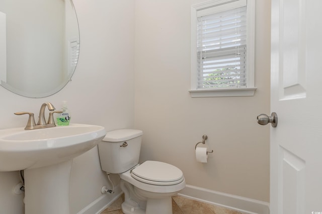 bathroom with sink, toilet, and tile patterned flooring