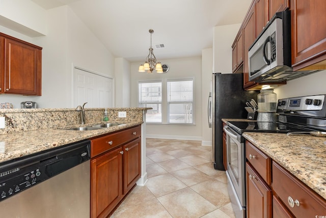 kitchen featuring sink, stainless steel appliances, light stone counters, and pendant lighting