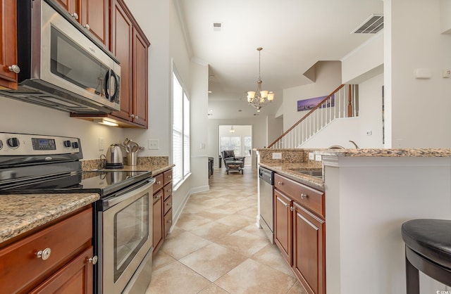 kitchen featuring light stone countertops, stainless steel appliances, hanging light fixtures, a chandelier, and crown molding