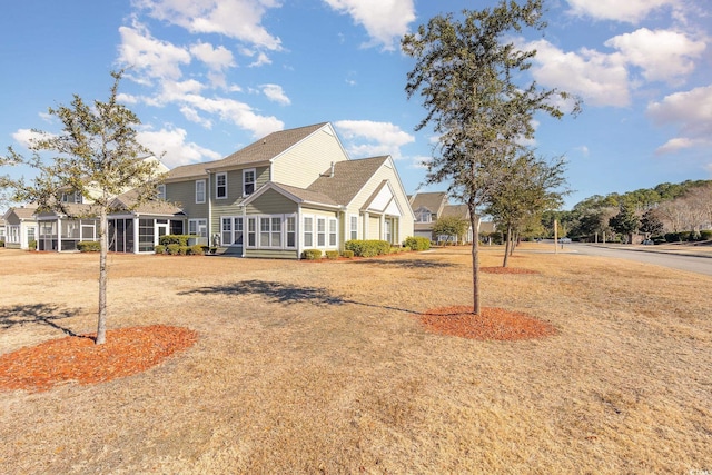 view of front of property featuring a front yard and a sunroom