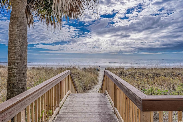 view of home's community featuring a water view and a beach view